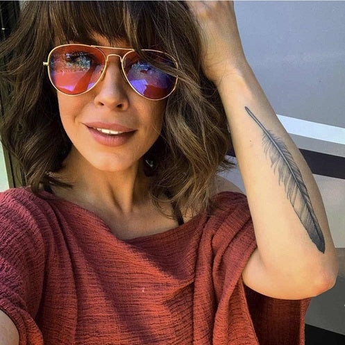 Woman wearing Sleep Swannies Aviator blue light blocking glasses with orange lenses by Swanwick Sleep for better sleep. How to sleep better?